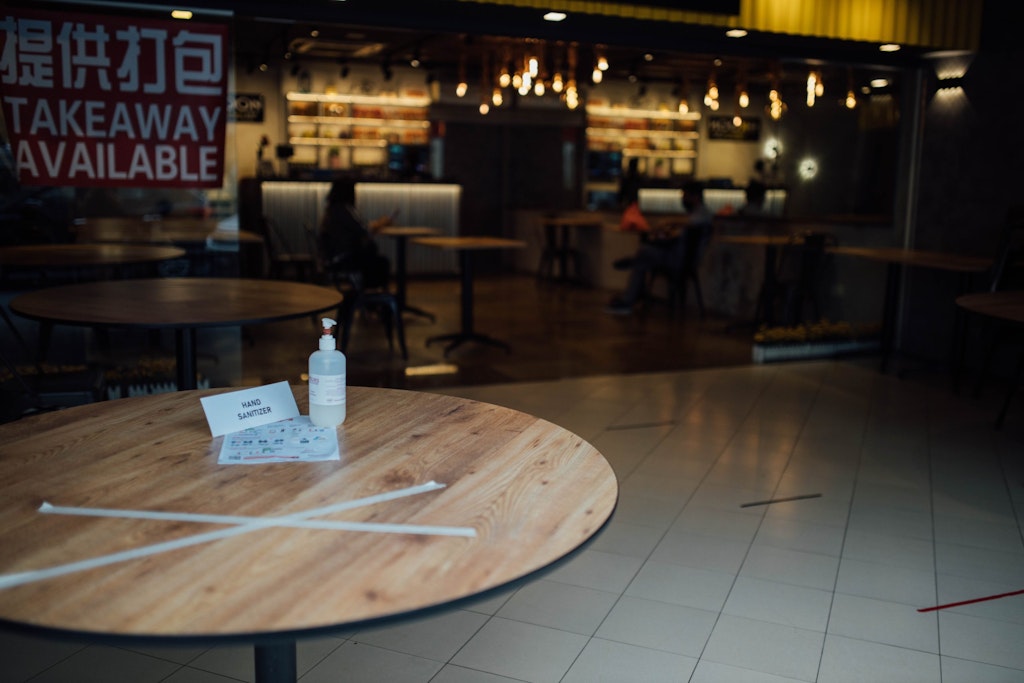 Hand sanitizer on a table in the entrance of an empty restaurant