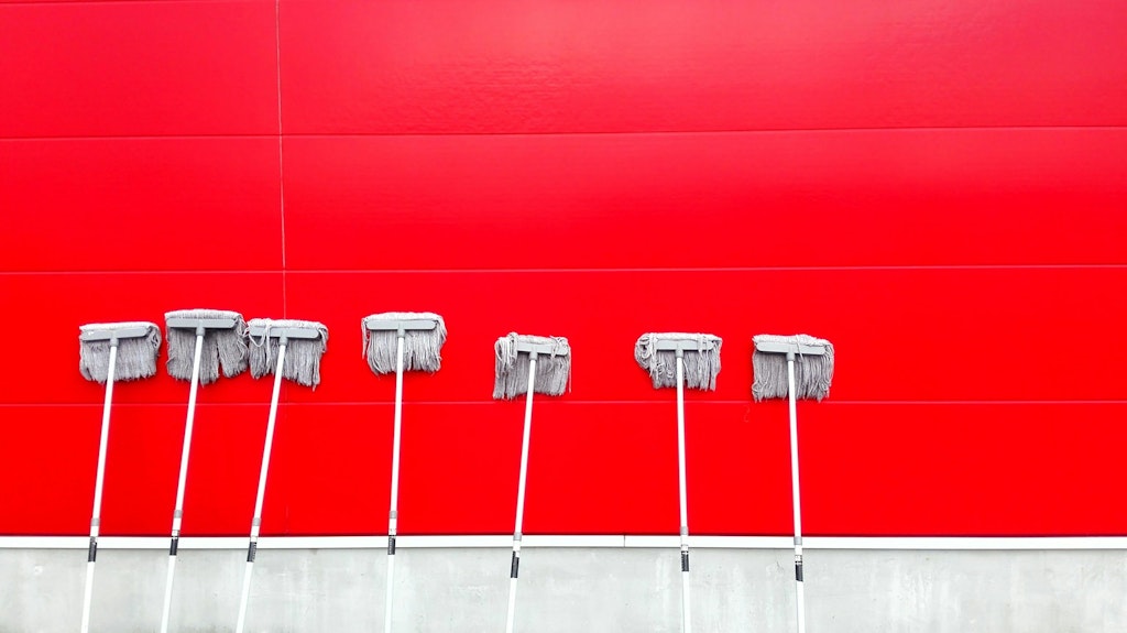 mops against a red wall