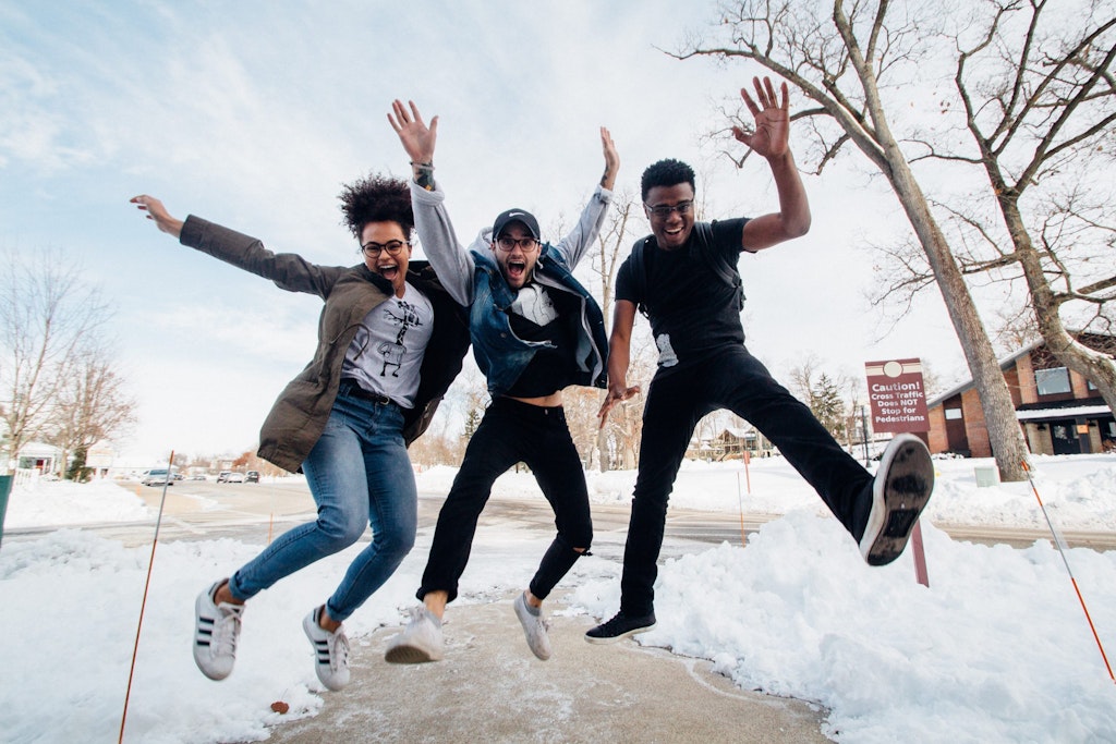 3 Happy people jumping outside in the snow