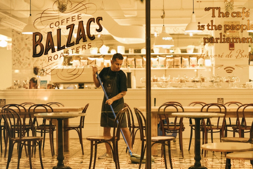 man mopping floor of coffee shop